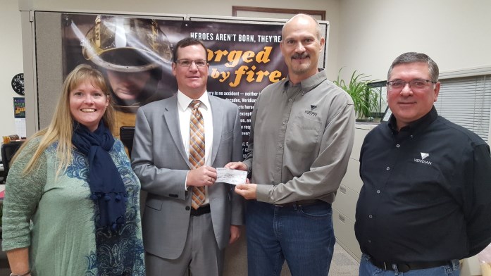 Spencer Area Jobs Trust President Ryan Johnson presents a check to Bill Van Lent and staff of Veridian Fire Protective Gear for the business’s participation in the organization’s Internship Program.