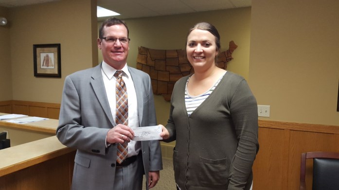 Spencer Area Jobs Trust President Ryan Johnson presents a check to Kristine Devereauz with Williams and Company for the business’s participation in the organization’s Internship Program.