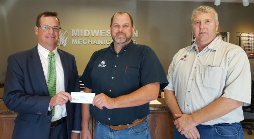 Ryan Johnson, Jobs Trust President presenting check to Donavan Wunschel and Gary Terwee at Midwestern Mechanical, Inc.